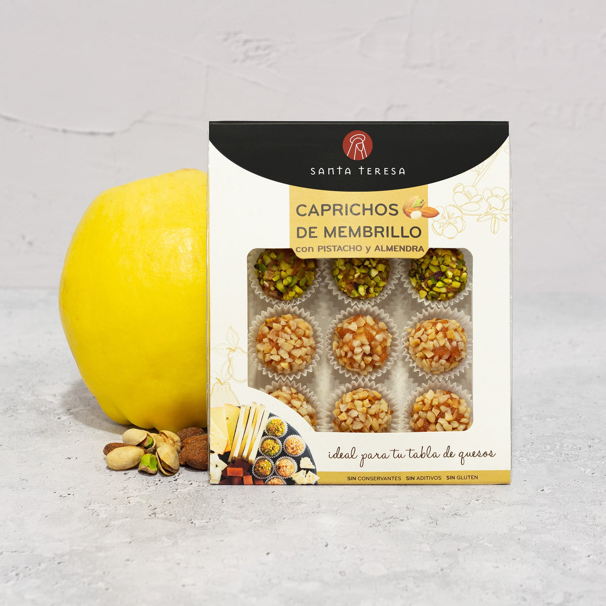 Estuche de Caprichos de membrillo Santa Teresa de 120 g con pistacho y almendra, junto a membrillo fresco y frutos secos