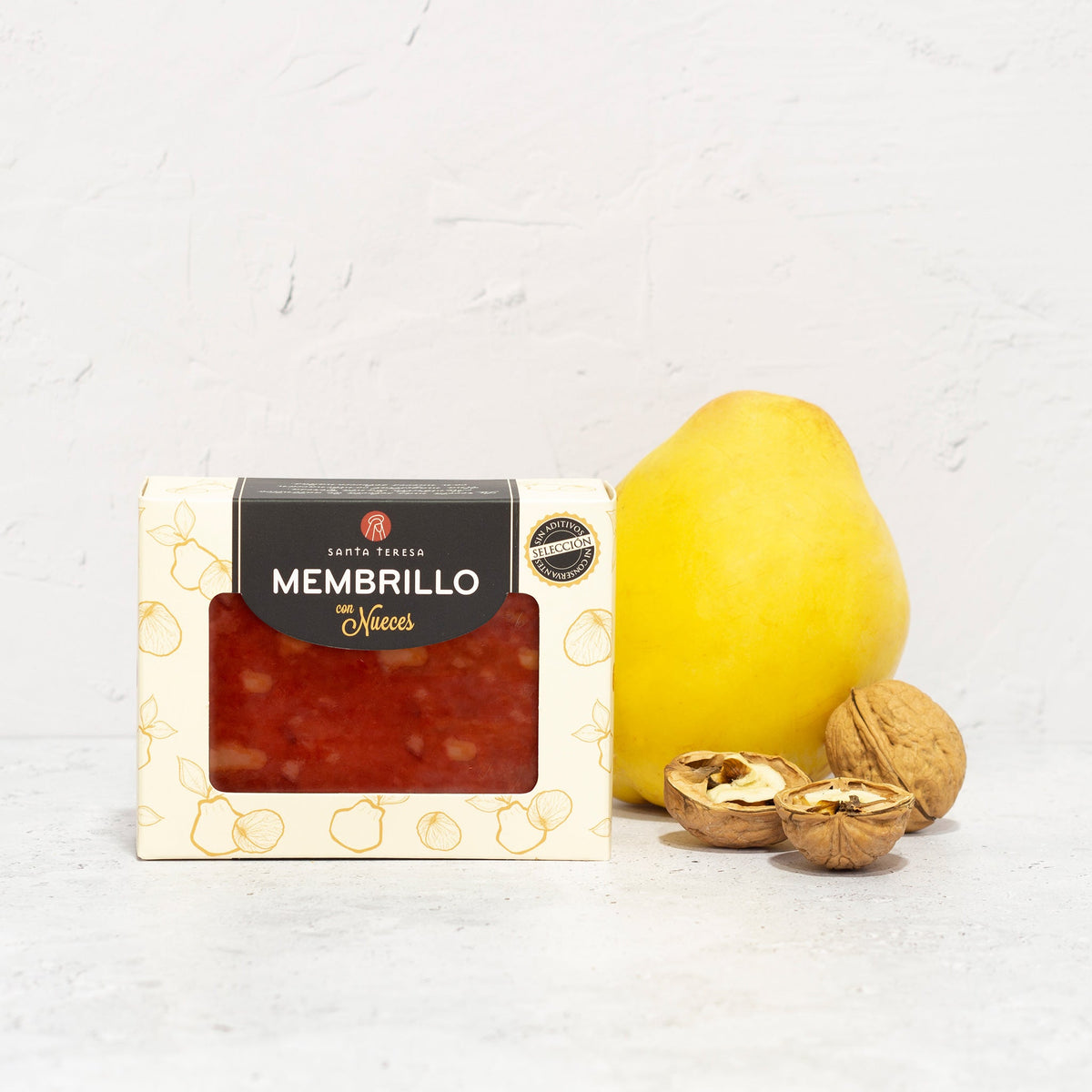 Envase de membrillo con nueces Santa Teresa de 310 g, junto a un membrillo y nueces